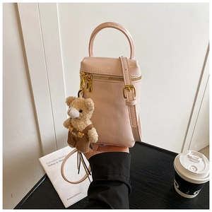 Sac bandoulière en cuir verni rose avec fermetures dorées et pendentif d'ours en peluche