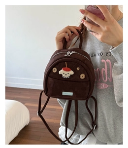 Detail of dark brown faux suede mini backpack with dog embroidery and wooden buttons