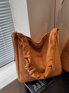 Vintage brown suede tote bag with drawstring details and pleated shoulder strap