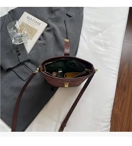 Detail view of bucket bag interior showing space for phones, lipstick and small wallet