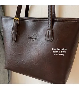 Close-up of brown pebbled leather tote bag with gold hardware and New York embossed logo