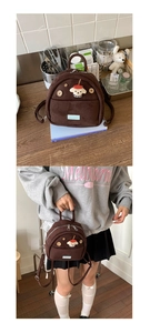 Detail of mini brown suede backpack featuring a 3D cartoon puppy patch and wooden buttons