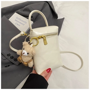 Détail du mini sac de téléphone crème en similicuir avec un joli pendentif ourson