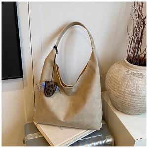 Detail of khaki hobo tote bag with leopard print eyewear case hanging on the strap