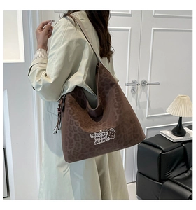 Detail of leopard print tote bag with bear patch on soft suede fabric modeled at home