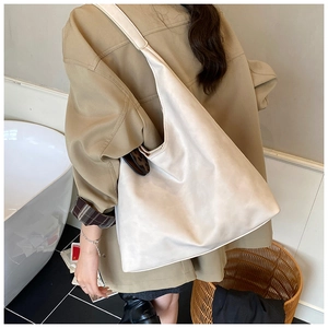 Lifestyle shot of cream white faux leather tote bag with wide strap for daily commute