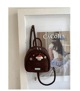 Detailed close-up of brown suede mini backpack with cute dog patch and wooden buttons