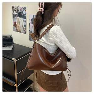 Détail du sac vintage marron foncé avec lanières tressées et détails de laçage
