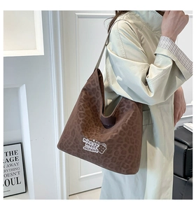 Close-up of leopard print canvas tote bag with graphic text and cartoon detail