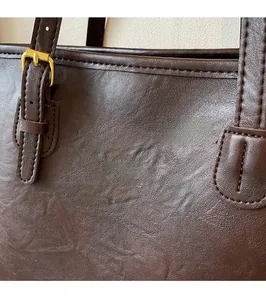 Detailed close-up of dark brown leather tote with fashion bag NEW YORK embossed lettering