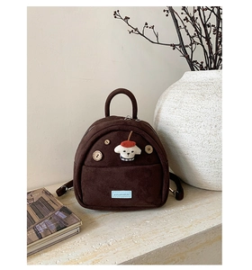 Detail of vintage brown suede mini backpack with dog patch and wooden button detail