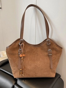 Brown frosted suede tote bag with contrast leather handles and vintage tassel charm