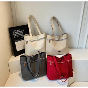 Detail of four color canvas tote bags featuring zig-zag stitching and Docile-girl logo