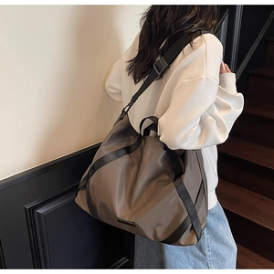 Braune Reisetasche am Modell mit großem Fassungsvermögen und Nylon-Schultergurten