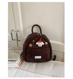 Detail of dark brown faux suede mini backpack with cartoon puppy patch and wooden button