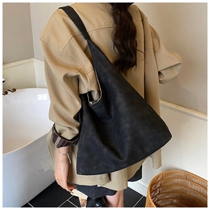 Detail of a large black matte tote bag showing the soft texture and integrated strap