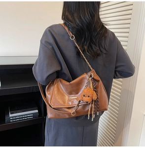 Brown faux leather shoulder bag with chain strap and teddy plush charm detail