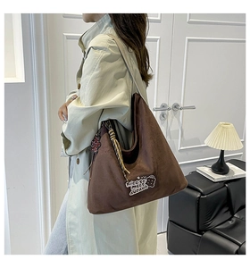 Detail of soft dark brown leopard print hobo bag with embroidered teddy bear patch