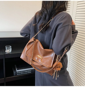 Detailed back view of vintage brown chain shoulder bag with a cute teddy bear charm