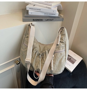 Detail of sage green pleated dumpling bag with drawstring and adjustable nylon strap