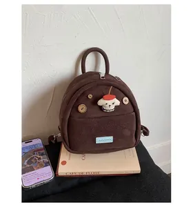 Detail of a brown mini suede backpack featuring cartoon dog patch and vintage wood buttons