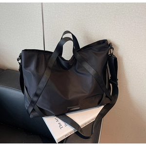 Detail einer schwarzen Nylon-Reisetasche mit wasserfestem Stoff und Schultergurt