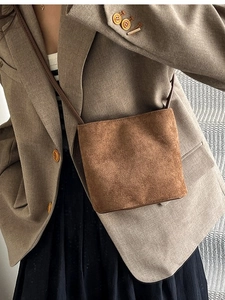 Minimalist brown suede bucket crossbody bag with slender leather shoulder strap for women