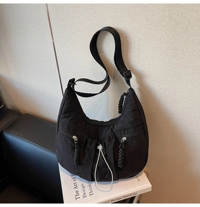 Detail of black nylon hobo bag showing pleated texture and adjustable drawstring design