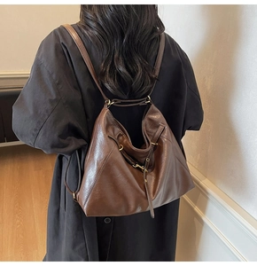 Detail of vintage dark brown faux leather backpack with metallic buckle and soft texture