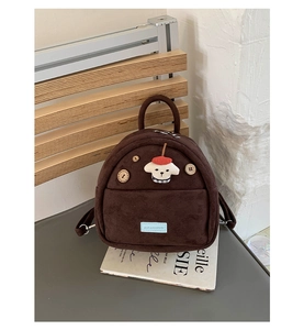 Detail of a brown suede mini backpack featuring a cute 3D cartoon dog and wood buttons