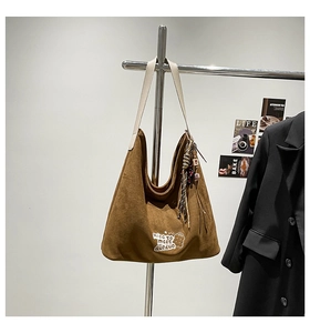 Detail of leopard print tote bag featuring brown suede texture and embroidered patch