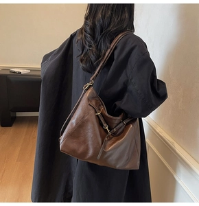 Detail of vintage brown tote bag with side drawstring and premium metallic hardware