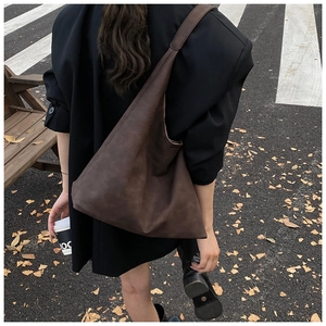 Detail of dark brown matte tote bag showing its large capacity and wide shoulder strap