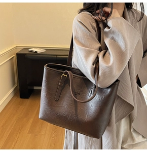 Close-up of deep brown leather tote bag with fashion bag NEW YORK engraving and gold buckle