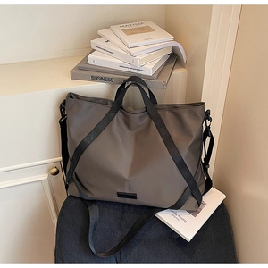 Detailaufnahme der braunen Nylon-Reisetasche mit schwarzen Griffen und Schultergurt