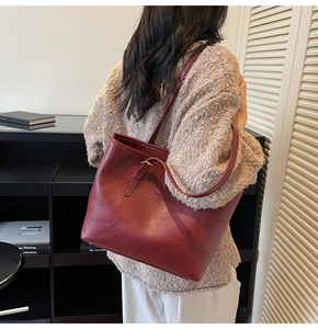 Detail of burgundy tote bag showing fine leather texture and fashion lettering print