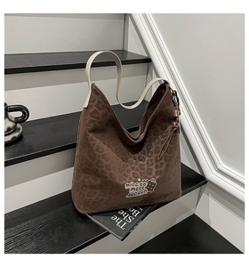 Detail of leopard print tote bag featuring a cute bear embroidery and wide cream strap