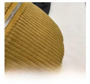 Detailed macro view of yellow corduroy fabric texture and premium silver metal zipper
