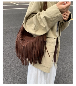 Dettaglio della borsa a tracolla in camoscio marrone con frange lunghe e stile bohémien