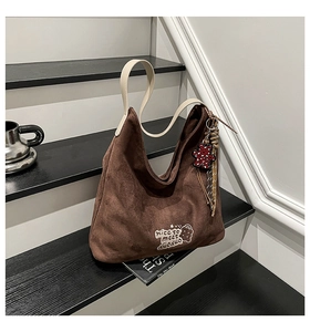 Detail of brown leopard print bucket bag with bear embroidery and red polka dot charm