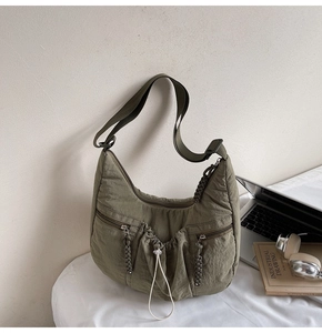 Macro shot of olive green pleated nylon crossbody bag with side drawstring details
