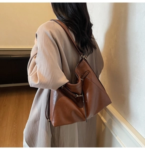 Detail of vintage brown leather tote bag with metallic buckles and oiled finish