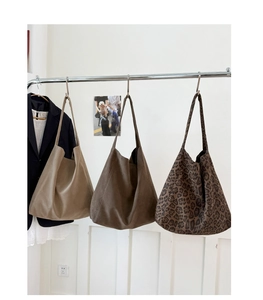 Detailed display of large leopard print and solid color canvas tote bags on a rack