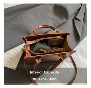 Internal capacity of the vintage brown satchel showing phone, lipstick and powder items