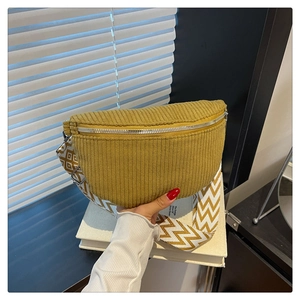 Detail view of mustard yellow corduroy crescent bag with geometric woven strap