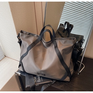 Makroaufnahme der grauen Reisetasche aus Nylon mit glatter Textur und stabilen Gurten