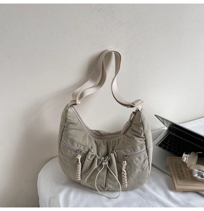 Detail of olive nylon crescent bag with pleated fabric and rope zipper pulls