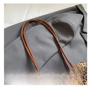 Detalle del bolso tote con estampado de leopardo, asas de cuero y adorno de felpa