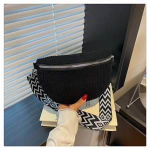 Detail of black corduroy saddle bag featuring a geometric pattern wide woven strap