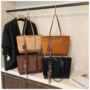 Detailed display of four vintage large tote bags with matte suede finish and bear charms